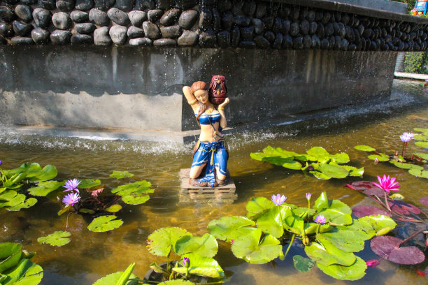 这座雕像位于水上，有莲花。图片下载
