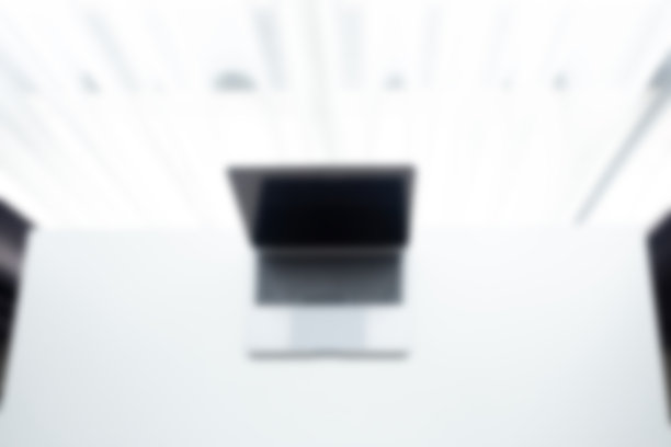 照片模糊办公桌办公地点的笔记本电脑在白色的桌子和黑色的椅子在家庭办公室图片下载