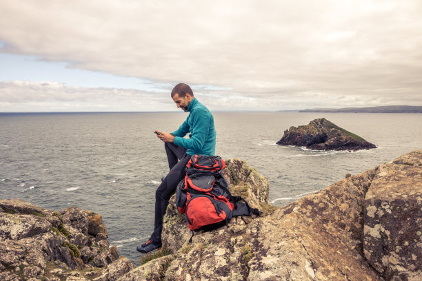 游客探索英国康沃尔的岩石海岸图片下载