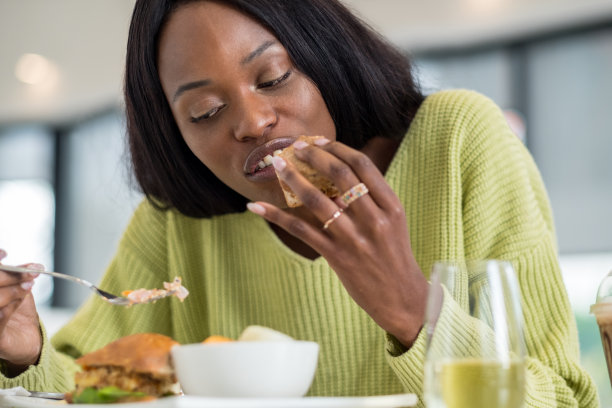 年轻的黑人妇女在吃午饭图片下载
