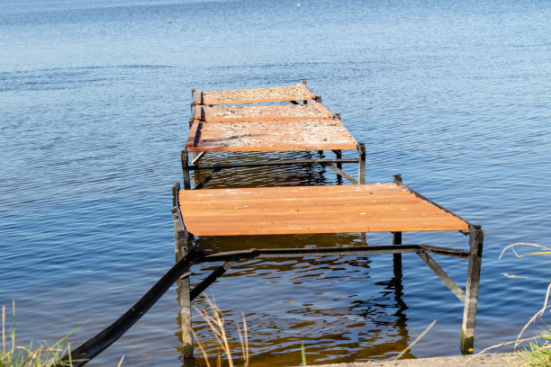 湖上的一座旧桥。停泊船的地方。秋天的季节。图片下载
