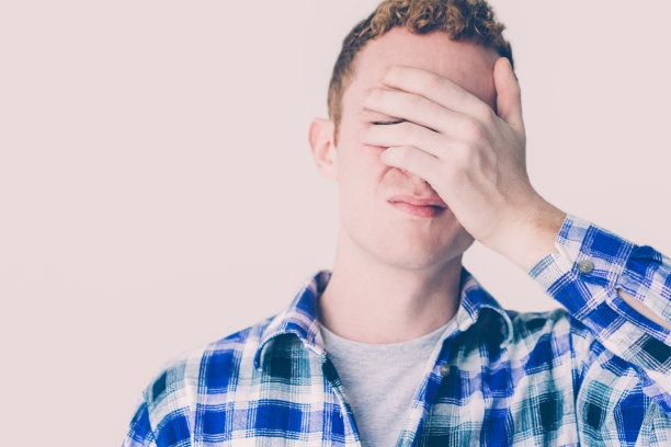恼怒的年轻白人男子用手遮住眼睛图片下载