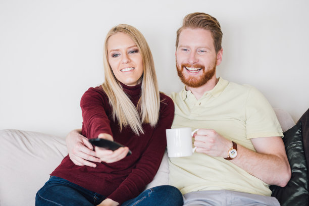 一对幸福的夫妇在客厅看电视图片下载