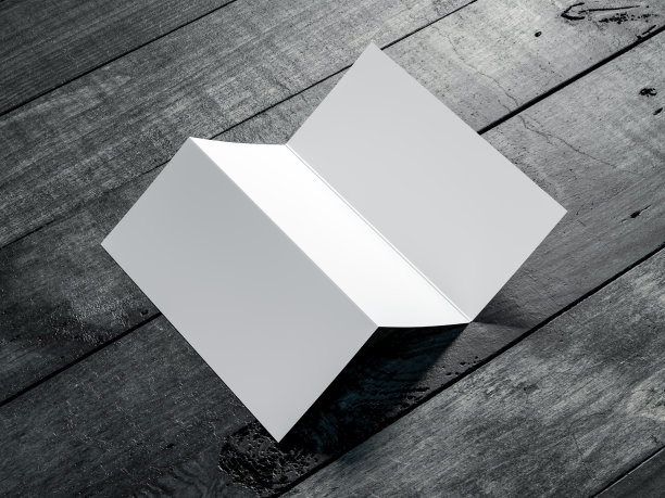 打开空白传单模型，在贺卡或邀请上的顶部视图在深色木桌上图片下载