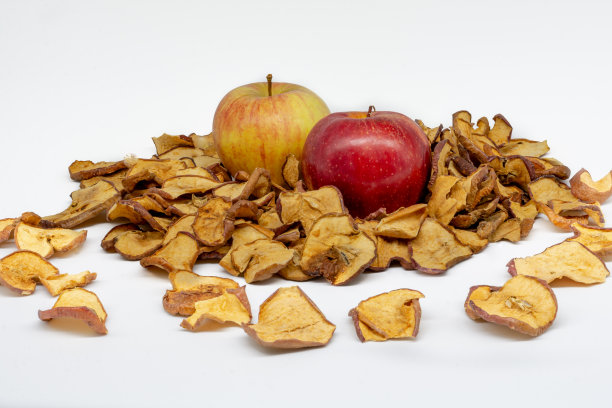 被脱水苹果片包围的两个苹果的裁剪视图图片下载