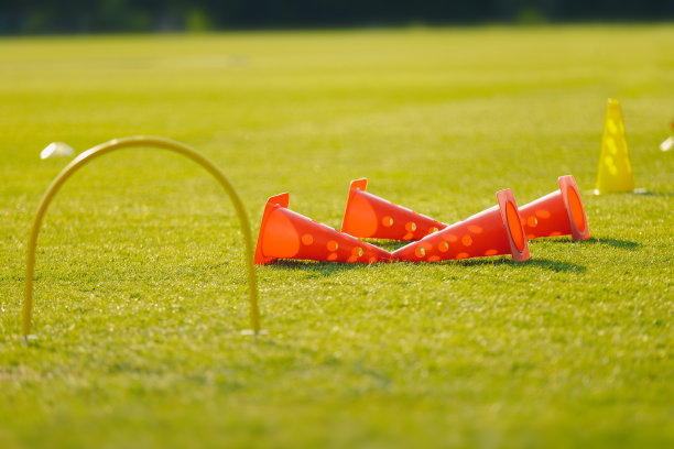 足球训练器材的练习环节。空旷足球场中的足球设备图片下载