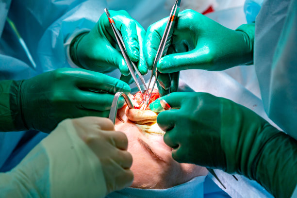 外科医生和他的助手在医院的手术室里为鼻子做整容手术。鼻子重塑,增大。鼻整形术。图片下载