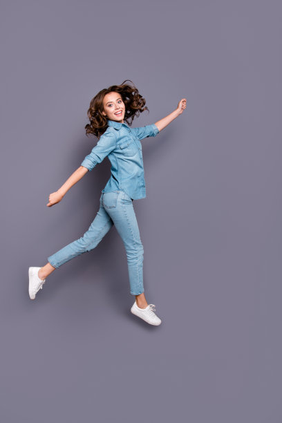 丰满的身材长度漂亮的疯狂时尚开朗迷人的可爱的女孩波浪发型在休闲牛仔衬衫和牛仔裤，去在空气中，鬼混，孤立在灰色的背景图片下载