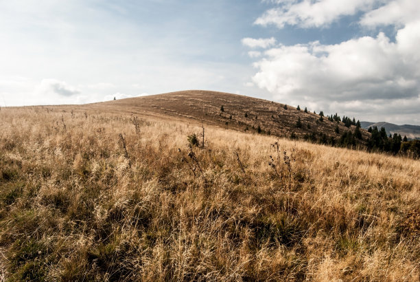 秋天的山地草地与蓝天和云彩和其他山的背景图片下载