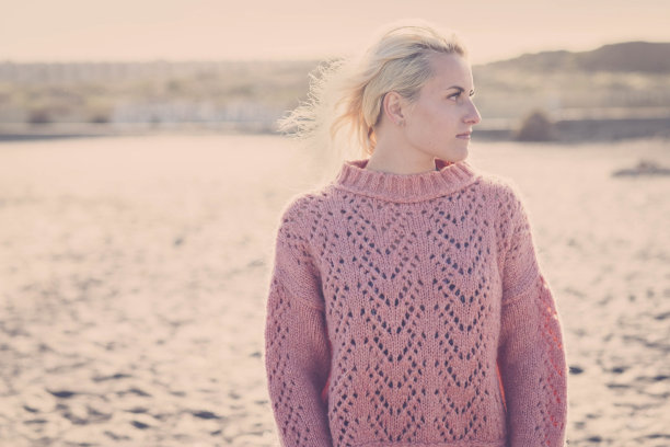 户外沙滩肖像美丽的金发白种人模特在户外度假景区。晴天和背光漂亮的年轻女孩在刮风的日子。暖色调和黄色调图片下载