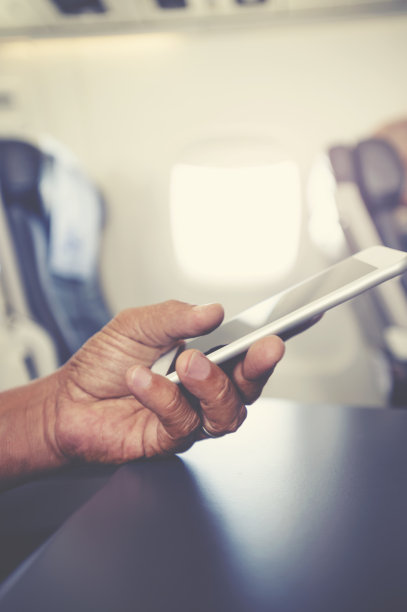 在飞机上使用手机的男人图片下载