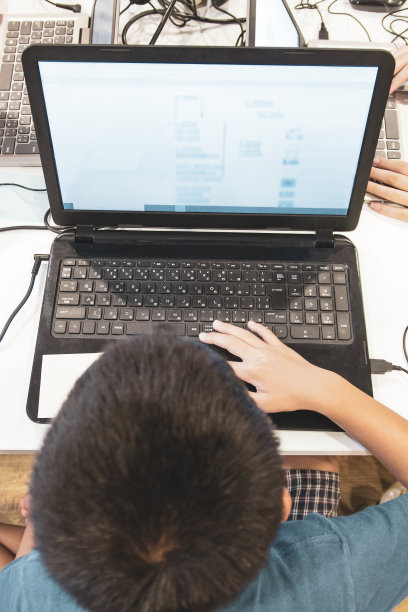 亚洲男孩用笔记本电脑学习编程，俯视图图片下载