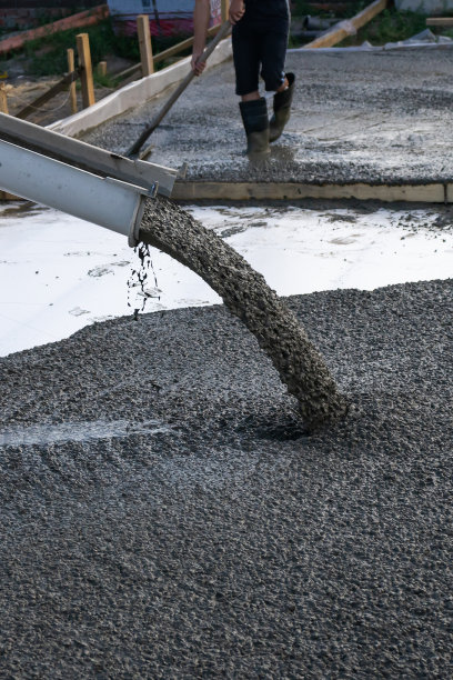 工人们用流动混凝土搅拌机为建造住宅楼浇筑地基。图片下载