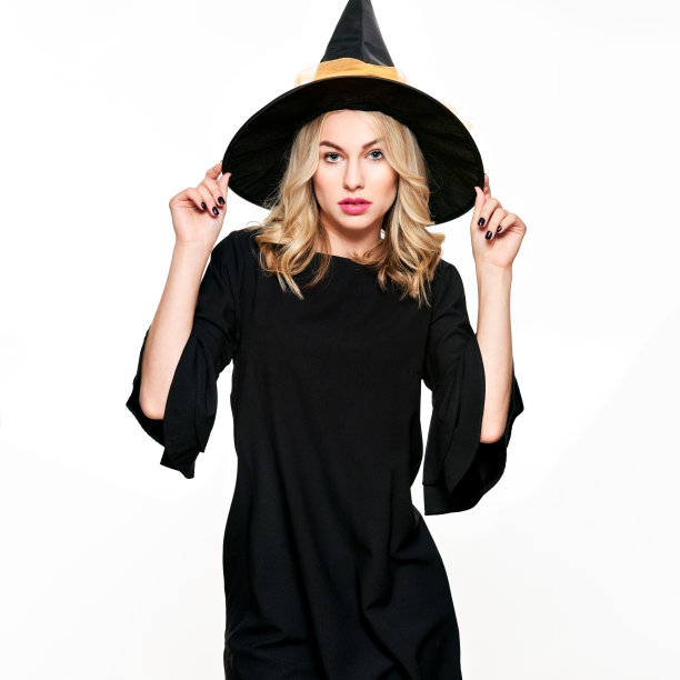感官万圣节女巫工作室肖像。迷人的年轻女子穿着女巫万圣节服装孤立在白色的背景。图片下载
