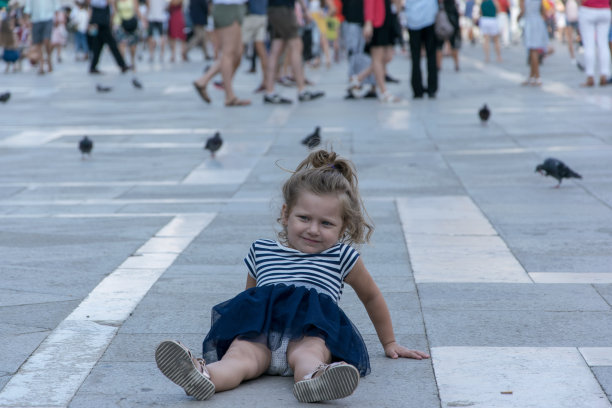 小女孩坐在圣马可广场的地上图片下载