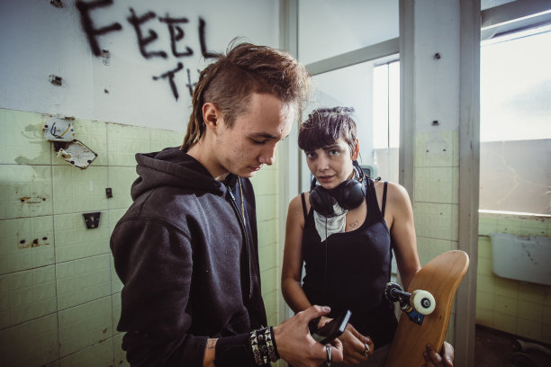 一对青少年情侣在贫民区闲逛图片下载