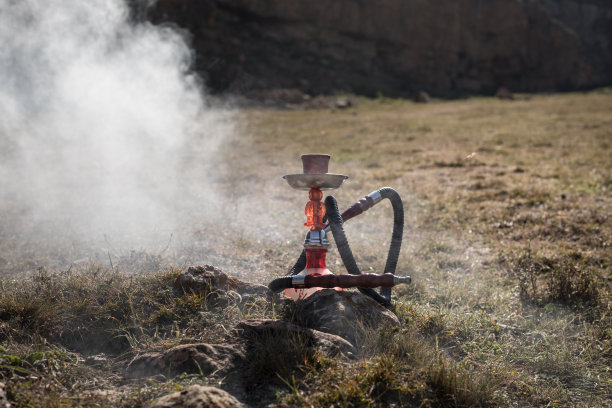 水烟，传统阿拉伯水管，直接日落光，户外照片。山的背景或水烟的剪影在日落的背景。户外。有选择性的重点图片下载