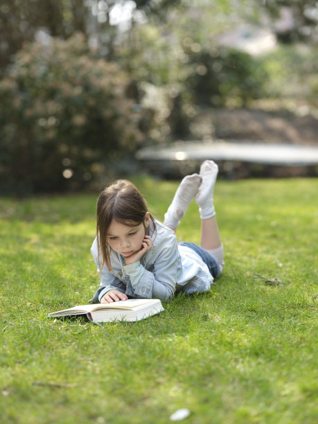 女孩在花园里看书图片下载