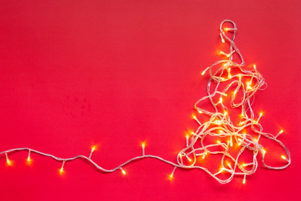圣诞暖白黄色led灯排列在松树形状的红色背景与复制空间为圣诞文字装饰或新年图片下载