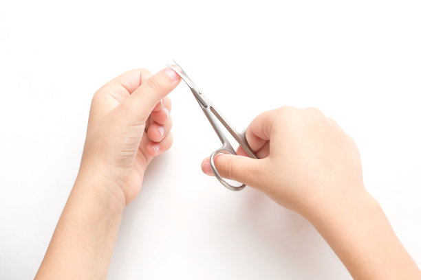 一个小孩在家里用修指甲剪刀剪指甲。在白色的背景上图片下载