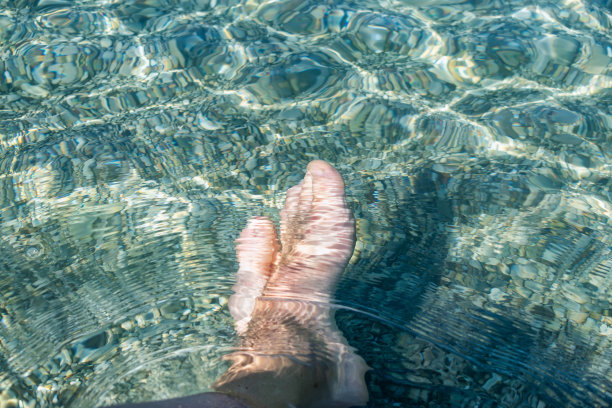 近距离的图片赤脚男人的腿在海水中图片下载