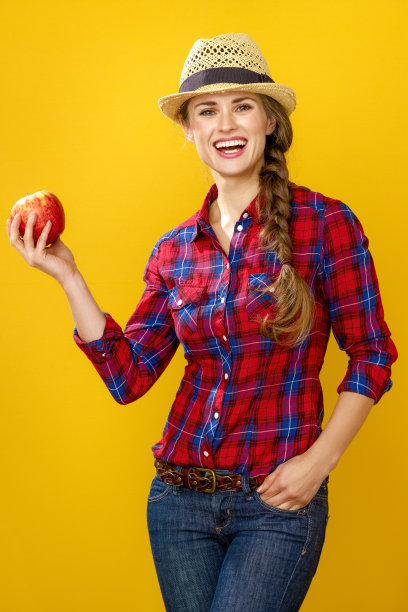 一名妇女被隔离在黄色背景上，显示一个苹果图片下载