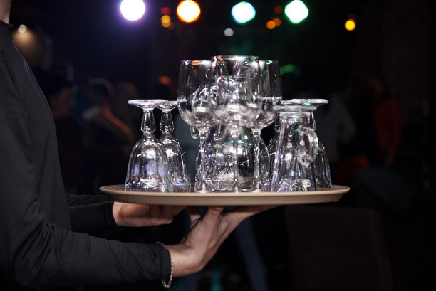 服务员端着一个托盘，上面有干净的空杯子。图片下载