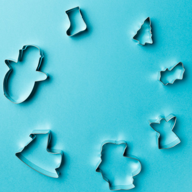 圣诞饼干各种形状刀具在蓝色背景与复制空间。前视图。平的。时尚的彩色照片。以彩色纸为背景的简约风格。圣诞节的概念。图片下载