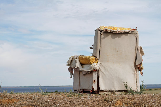 河边被遗弃的旧扶手椅图片下载