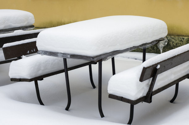 冬天木头桌子上覆盖着一层厚厚的雪图片下载