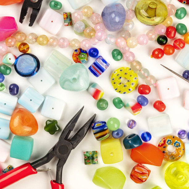 头顶上是许多不同的珠子和制作珠宝的工具的照片图片下载