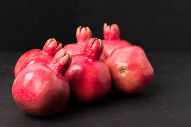 成熟的红石榴特写摄影在黑色的背景。图片下载