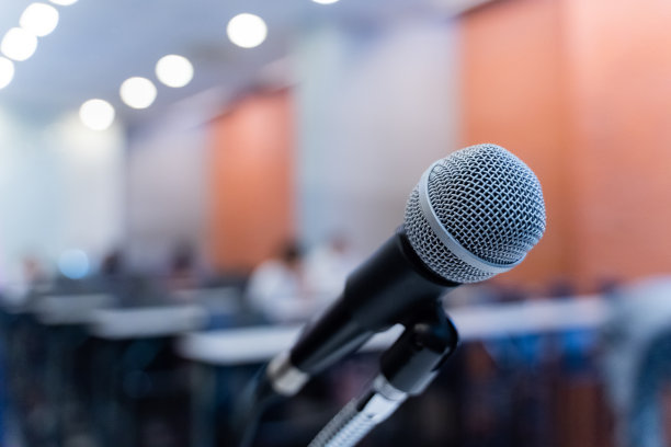 麦克风通过模糊的商务论坛会议或会议培训学习辅导室概念与噪音，模糊的背景。图片下载