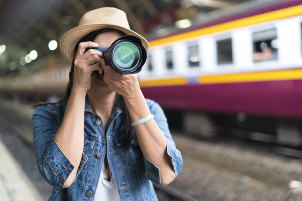 女摄影师在火车站拍照图片下载