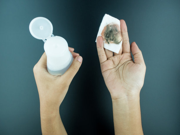 卸妆后的化妆棉与清洁瓶在黑色背景图片下载