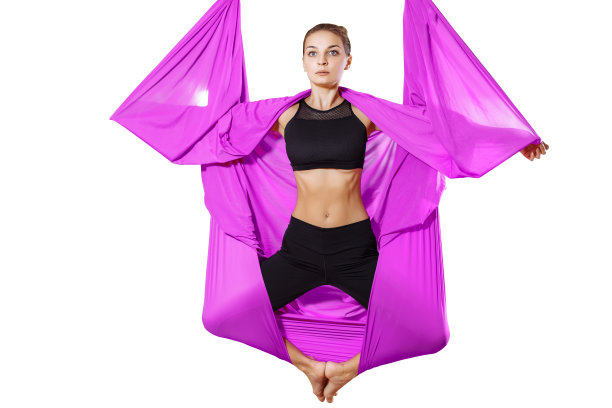 年轻迷人的女子在吊床上做体式。空气瑜伽。图片下载