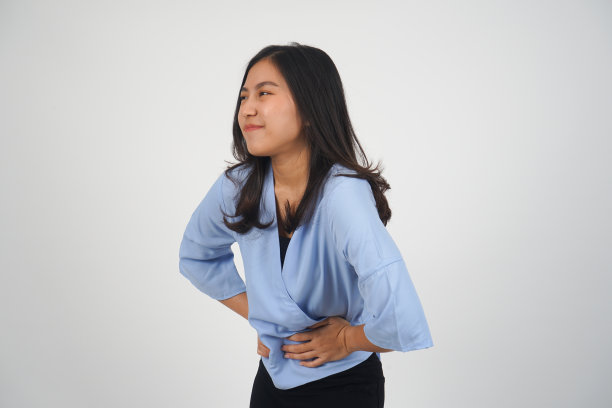 经期痉挛亚洲妇女-孤立图片下载