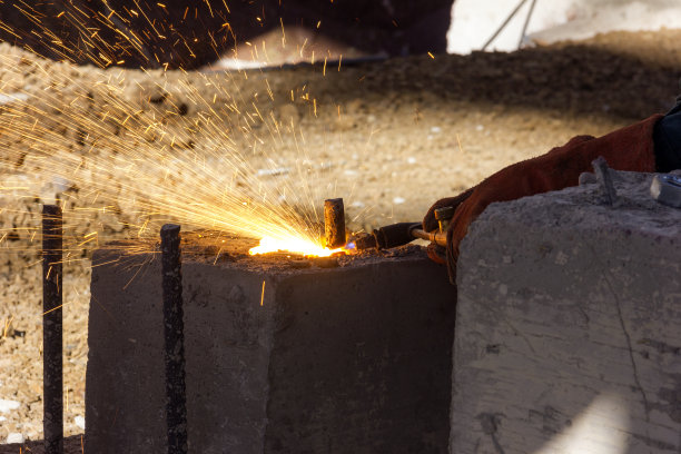 焊工用含氧燃料切割钢筋。氧燃料工艺是目前应用最广泛的工业热切削工艺。该设备成本低，可手动或机械化使用。图片下载