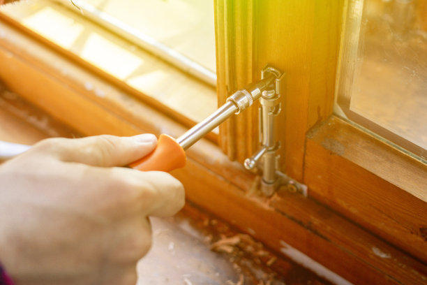 靠近工人的手工作调整钢螺栓闩上的木窗f图片下载