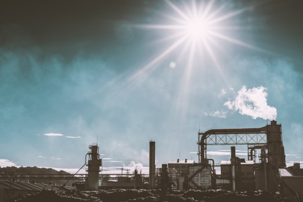 日落时分，工业大楼上的烟囱在冒烟。图片下载