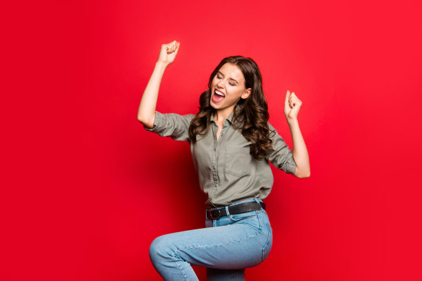 成就的概念。侧面的照片华丽，好看的人在休闲衬衫举起拳头，眼睛近距离孤立在发光的红色背景图片下载