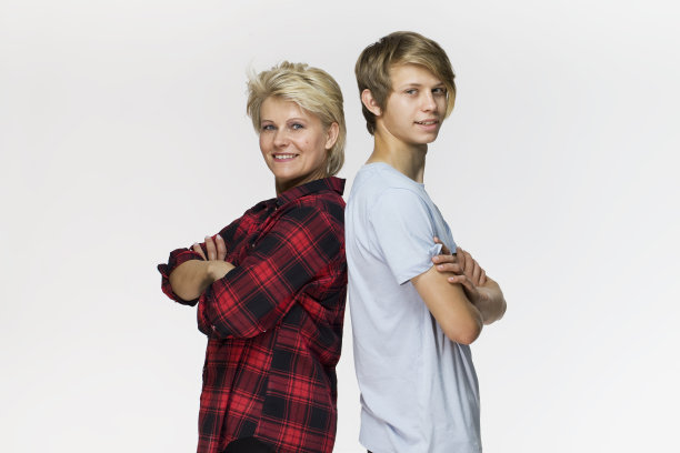 幸福的家庭，母亲和儿子交叉双臂微笑肖像对白色的背景图片下载