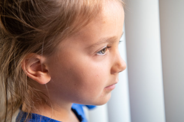 一个白人小孩向窗外看图片下载