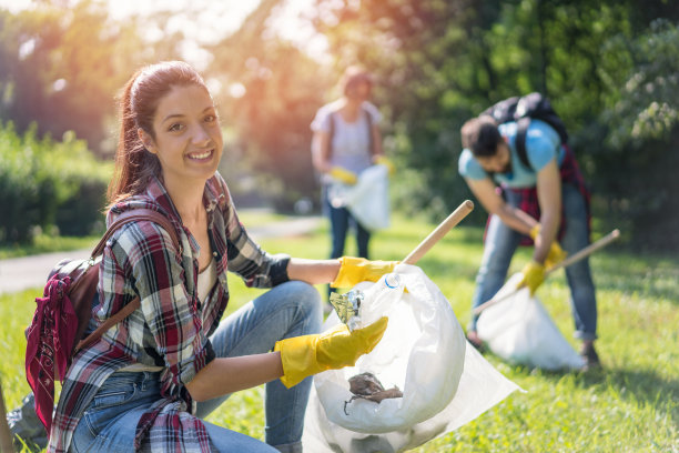 在公园里清理塑料垃圾的年轻女子图片下载