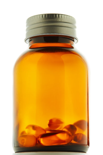 棕色的玻璃药瓶，里面有一些药丸，背景是白色图片下载