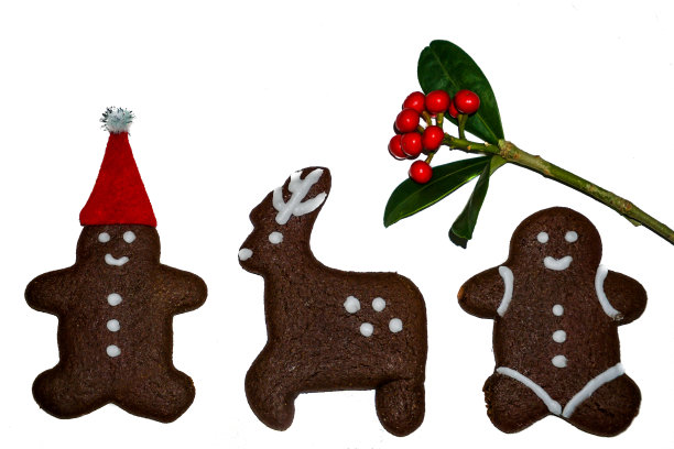 姜饼人饼干在圣诞老人的红帽子特写，孤立，白色背景。圣诞饼干装饰点子。图片下载