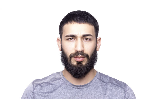 英俊的年轻人的肖像看着相机与空白的面部表情在一个白色的背景图片下载