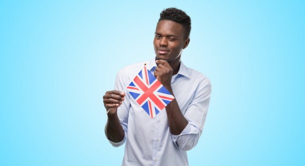 年轻的非裔美国人举着英国国旗严肃地面对问题思考，非常困惑的想法图片下载