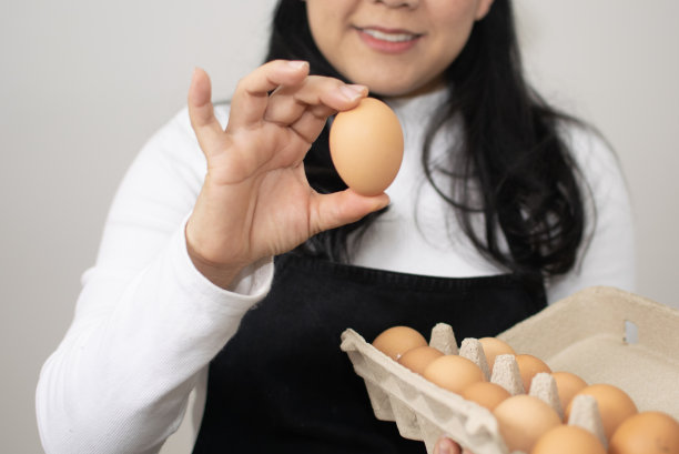 厨房里的女人拿着从农场来的新鲜鸡蛋，特写图片下载