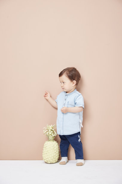 一个穿着牛仔裤的小男孩，一件在他膝盖前看起来很可爱的衬衫。图片下载